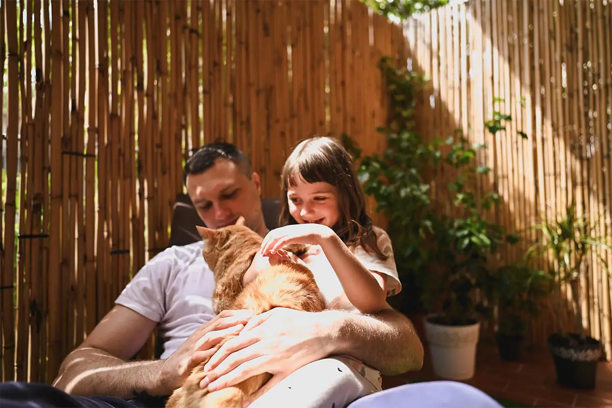 Family with their cat outside